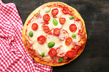 Delicious pizza with cheese and cherry tomatoes on wooden table, top view