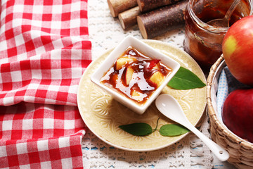 Apple jam and fresh red apples on wooden table close-up