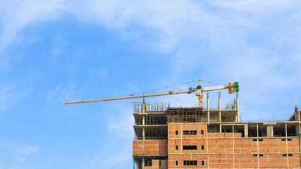 Building crane and construction site under blue sky