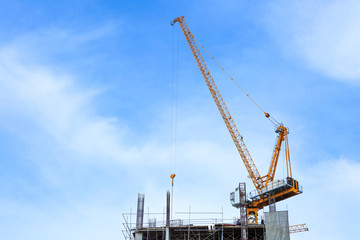 Fototapeta na wymiar Building crane and construction site under blue sky