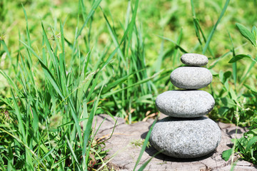 Fototapeta na wymiar Stack of spa stones over green grass background