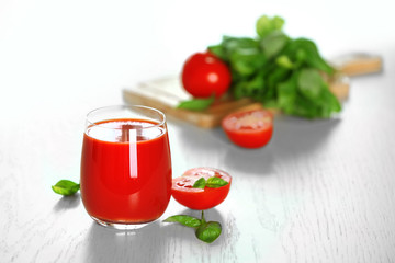 Tomato juice and fresh tomatoes on wooden table close-up