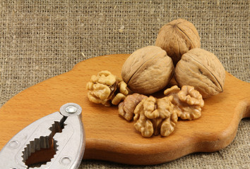 Walnuts on a wooden board (cutting board) with a nutcracker