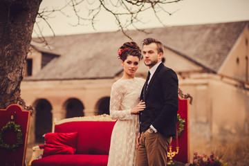 Fashionable cool couple standing near vintage couch