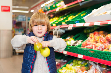 Little boy choosing fruits in a food store