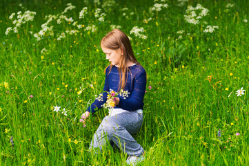 Fototapeta premium Cute little girl picking wildflowers