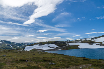 Road in summer snow highland under blue sky