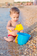 cute baby boy playing on the beach