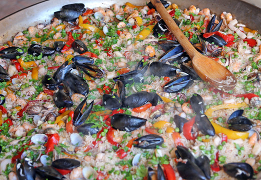 Paella rice with clams and mussels and green peas