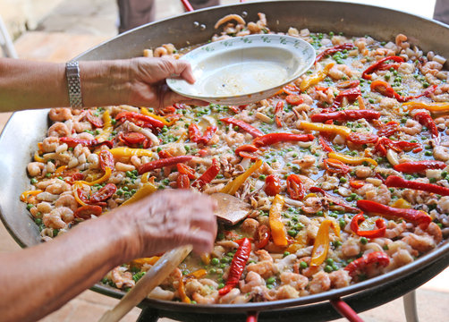 Hand Of The Chef Adds Shrimp In Rice Paella With Seafood