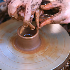 Hands working on pottery wheel