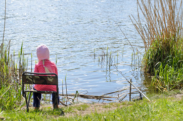 Fototapeta na wymiar Young Girl Sitting on Chair at Waters Edge