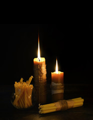 Antique candles burning in the darkness