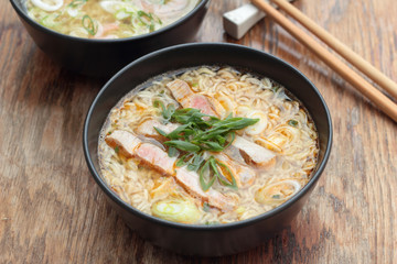 Bowl of oriental noodle and pork soup.