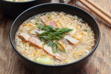 Bowl of oriental noodle and pork soup.