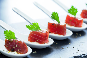 Tuna appetizers on ceramic spoons.