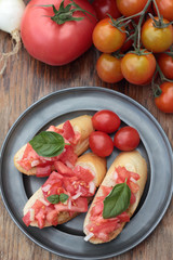 Three pieces of bruschetta on a tin plate.