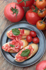 Three pieces of bruschetta on a tin plate.