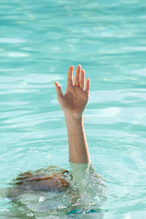 Hand of drowning person stretching out of water
