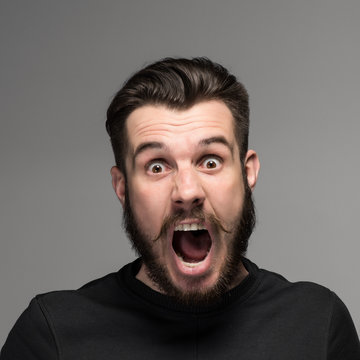 Portrait of a young surprised businessman with opened mouth