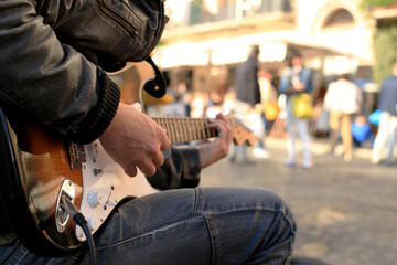 A street musician plays guitar on the square