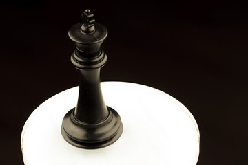 black king of chess on a white glowing circle