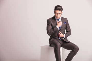 Attractive young business man fixing his tie