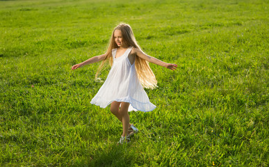 Little girl running along the meadow.