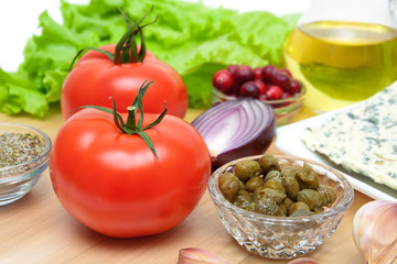 Ripe tomatoes and other foods on a cutting board