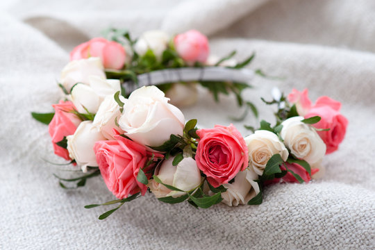 tiara of artificial roses on wooden background.