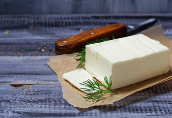 Fresh butter and knife on wooden background