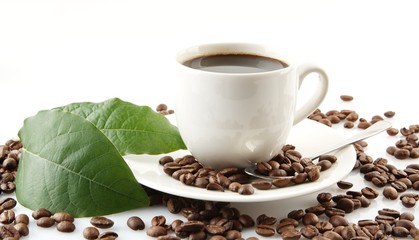 Scattered coffee beans with cups of coffee and leaf
