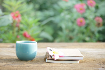 Notebook  and coffee in blue mug on wooden table