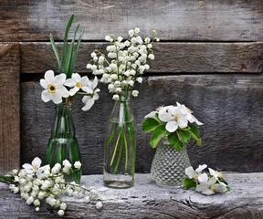 Fototapete Maiglöckchen Kleine Vasen und Flaschen mit Lilien, Narzissen und blühendem BH