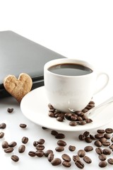 Cropped cup of coffee with laptop at breakfast