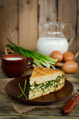Pie with onions and eggs on the wooden table