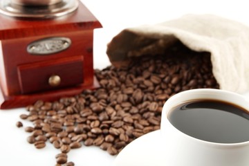 Cup of coffee with mill,bag full of coffee beans on white