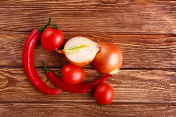 Fresh red tomato ,chilli,and onion in table wooden background
