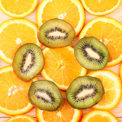 Oranges, kiwi on a wooden surface (seen from above)