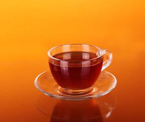Glass cup of tea on an orange background