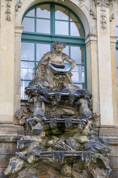 Closeup half naked faunus statues fountain at Zwinger palace in