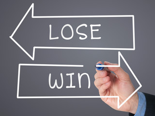 Man Hand drawing Win or Lose concept with white marker 