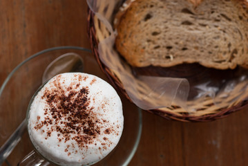A cup of hot cappuccino and bread