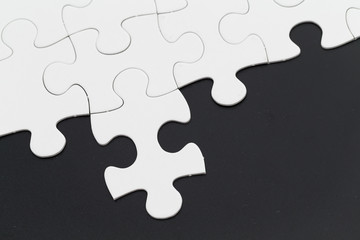 Obraz premium Plain white jigsaw puzzle on Black background