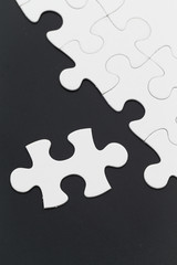 Plain white jigsaw puzzle on black background