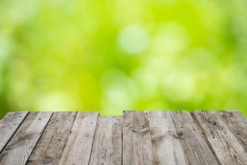 Empty wooden table with foliage bokeh