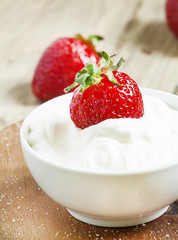 Fresh strawberries with cream, selective focus
