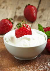 Fresh strawberries with cream, selective focus