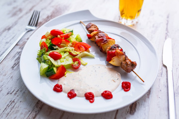 Grilled duck shashlik with salad on the plate