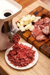 The electric meat grinder, forcemeat, onions and the cut meat